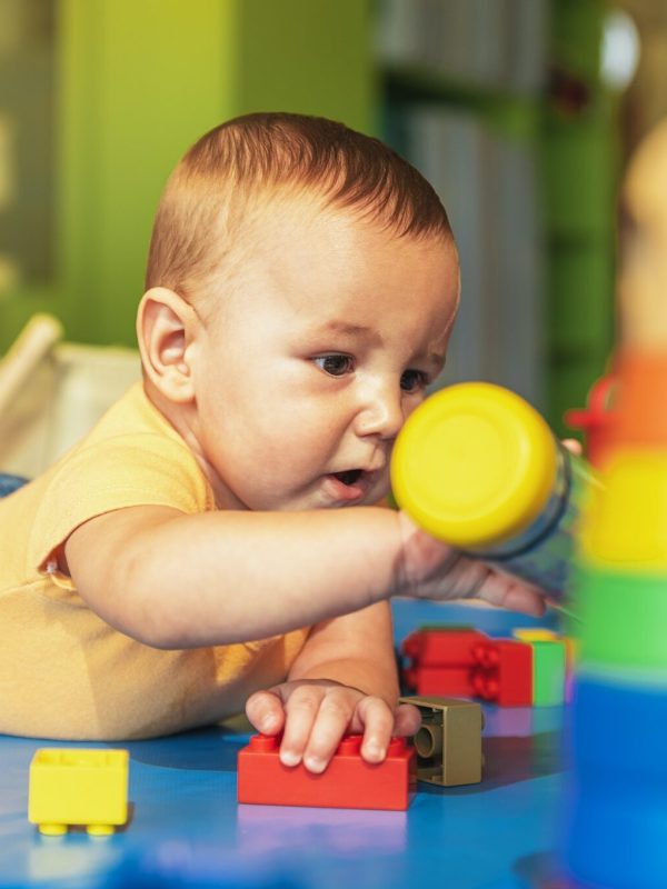happy-baby-playing-with-toy-blocks-in-the-kindergarten-.jpg